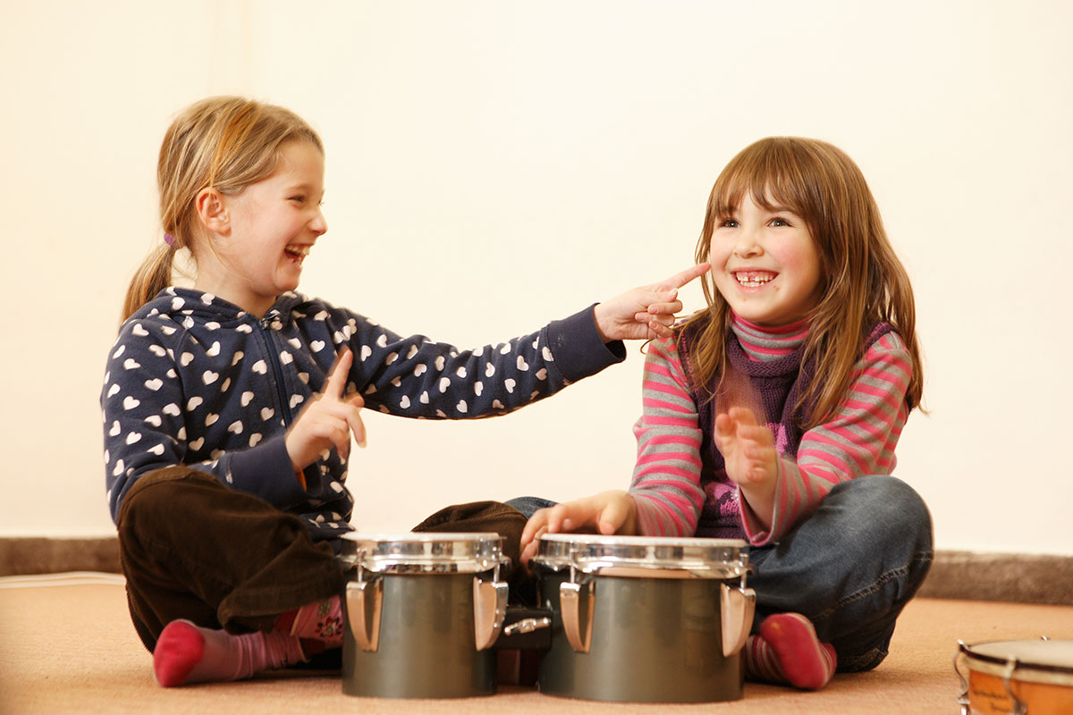 Zwei Vorschulkinder spielen auf einer Bongo