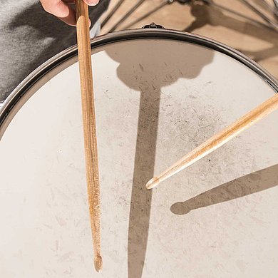 Spielende Hände mit Drumsticks auf einer Snaredrum