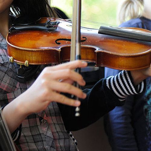 Drei Jugendliche üben Violine