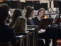 Auftritt einer jungen Pianistin mit konzentriertem Blick im Gemeinschaftskonzert.
