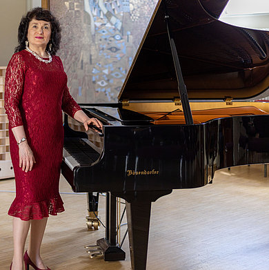 Frau neben Klavier