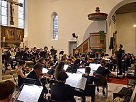 Orchester-Gesamtansicht, auf der das gemeinsame Musizieren des Musikschulorchesters "Saitenspiel" und der Kammerphilharmonie zu sehen ist.