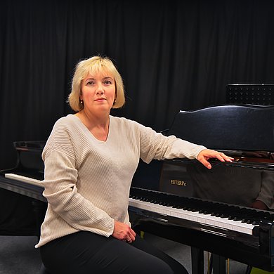 Pianistin sitzend am Klavier