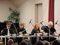 Drei Musikschüler und ihr Lehrer bei einem Percussionsspiel auf Büro-Alltagsgegenständen.