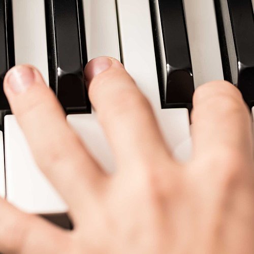 Spielende Hand auf einer Klaviatur