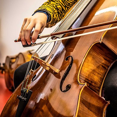 Jugendliche spielt auf einem Cello, Detailfoto des Cellokorpus