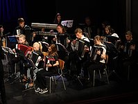 Teilaufnahme des Orchesters mit großen und kleinen Musikern. Im Hintergrund der Keyboardspieler.