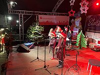 Zwei Mädchen singen ein Weihnachtslied mit Klavierbegleitung